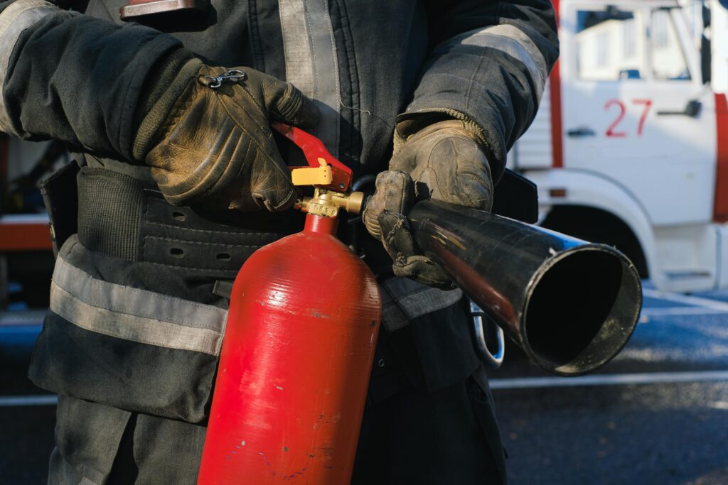 pexels-photo-5965211-5965211 Firefighter in uniform holding a fire extinguisher, emphasizing safety and emergency readiness.